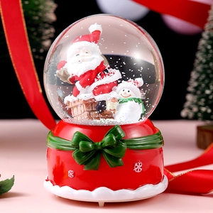 Close-up of Christmas crystal ball featuring Santa Claus and snowman with red base