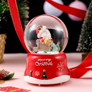 Detail of Christmas crystal ball featuring Santa and bear on a red embossed base