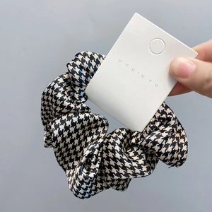 Detail of black and white houndstooth fabric scrunchie on a display card holder
