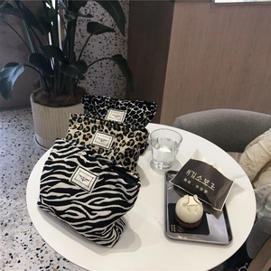 Chic animal print canvas makeup bags with Time to Party labels in a cafe setting