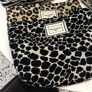 Detailed top view of leopard and spot print canvas makeup bags with Time To Party label