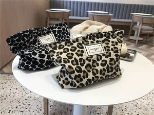 Detail of canvas makeup bags featuring black and white leopard print and party label