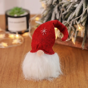 Close-up of Christmas gnome with red felt hat and snowflake embroidery on wood