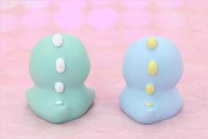 Rear view of mint green and sky blue cartoon dinosaur figurines for cake decoration
