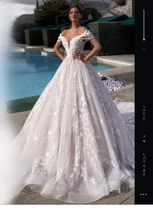 Close-up of V-neck wedding dress featuring exquisite lace appliques and pearl tassels