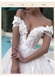Detail of V-neck wedding dress with 3D floral lace appliques and delicate white tassels