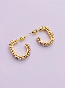 Detailed view of U-shaped gold earrings with micro-set square cubic zirconia