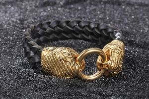 Detail of black braided leather bracelet featuring golden twin snake head buckle