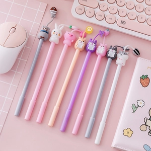 Set of 9 cute cartoon animal gel pens in pastel pink and grey on a pink desk workspace