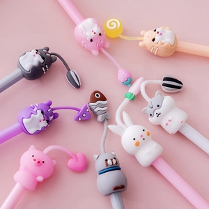 Cute cartoon animal gel pens with soft charms on a pastel pink background for students