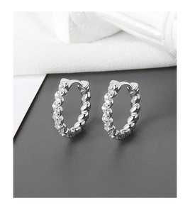 Detail of silver hoop earrings featuring twisted rope texture and sparkling zircon inlay