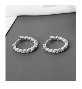 Macro view of 925 sterling silver hoop earrings with twisted rope design and pavé zircons