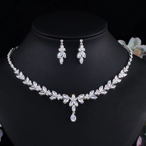 Detailed view of silver zircon jewelry set with leaf patterns on a black neck bust