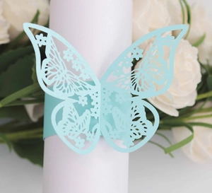 Macro shot of light blue laser-cut butterfly napkin ring on a white table setting