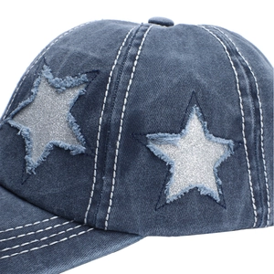 Close-up of distressed denim baseball cap featuring silver glitter star patch and stitching