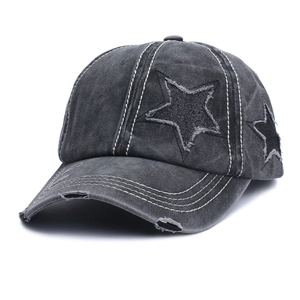 Close-up of distressed star patch and contrast stitching on washed grey baseball cap