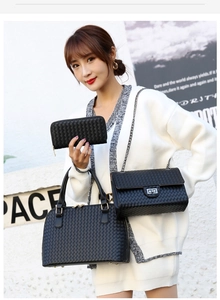 Close-up of black woven leather texture bag set including clutch and chain shoulder bag