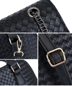 Detail showing high-quality black woven texture and polished gold hardware on fashion handbag
