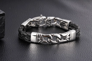 Detail of men's punk leather bracelet with vintage engraved silver metal clasp