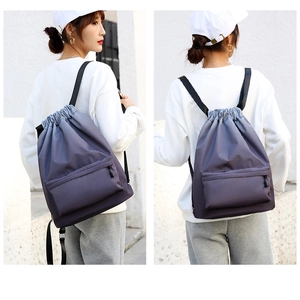 Vista laterale e posteriore di uno zaino in nylon grigio viola indossato da un modello in bianco