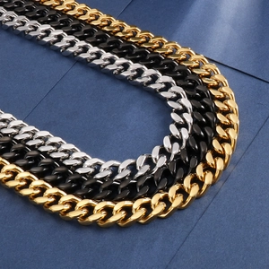 Close-up of cuban link chains in gold, silver and black finish on blue background