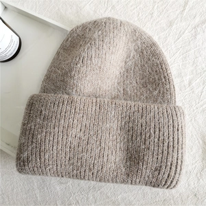 Detail of the thick knit texture and soft long rabbit fur surface on the khaki beanie
