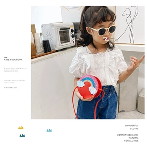 Detail of red circular PU leather toddler purse with glitter rainbow and white clouds
