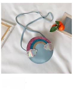 Close-up of girls rainbow glitter round crossbody bag with cloud patches on white fabric