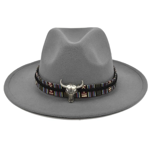 Close-up of a gray wool jazz hat featuring an ethnic woven band and silver bull head detail