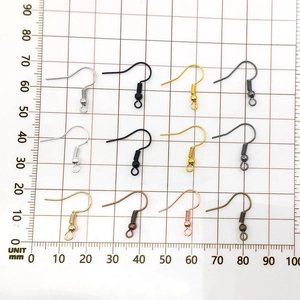 DIY jewelry earring hooks in assorted metal finishes displayed on a millimeter scale grid