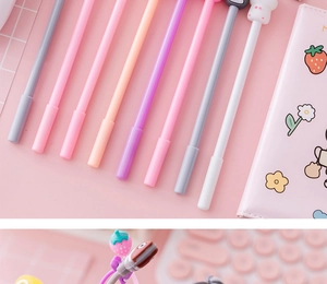 Detail of colorful cartoon gel pens and a pink strawberry notebook on a cute desk setup