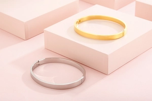 Bracelets polis en acier inoxydable doré et argenté sur blocs géométriques roses