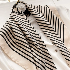 Close-up of beige and black striped silk scarf draped on a white shirt collar