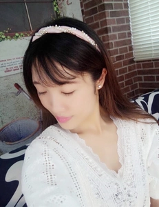 Pink twisted fabric headband with pearls shown on model with lace clothing