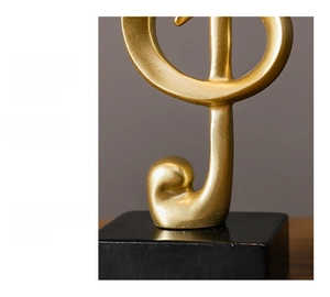 Close-up of golden resin musical note sculpture with matte finish and black square base