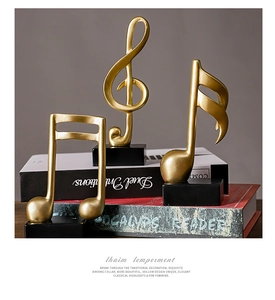 Detailed view of three golden musical note resin statues on elegant black bases