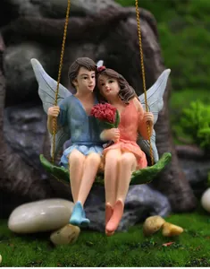 Detail of hanging resin flower fairy couple on a leaf swing for miniature garden decor