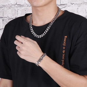 Street style men's silver Cuban link necklace and bracelet set worn by a male model