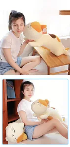 Detail of long calico cat plush pillows in two sizes on a white table in a cozy room