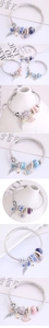 Detail eines Perlenarmbands mit bösem Blick, Flügelanhänger und blauen Harzperlen auf Draht