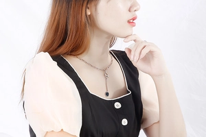 Close-up of rose gold letter N necklace with thick chain on a female model