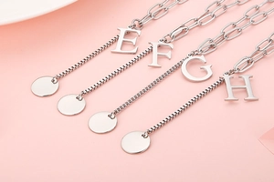 Detailed view of silver letter pendants E, F, G, and H with elegant polished metal finish
