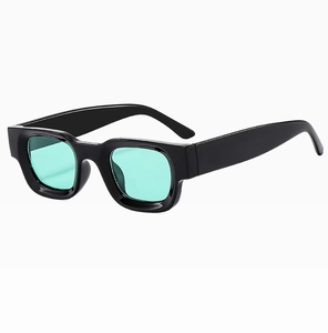 Macro side view of retro black square sunglasses with light green lenses and glossy frame