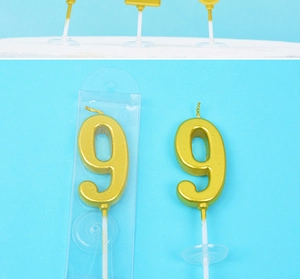 Detail of golden number 9 birthday candle with metallic finish and white plastic stand