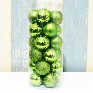 Detailed set of green Christmas baubles in matte, shiny, and glitter finishes in a clear tube