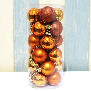 Macro detail of orange Christmas ornaments with matte, glossy and glitter finishes in a tube
