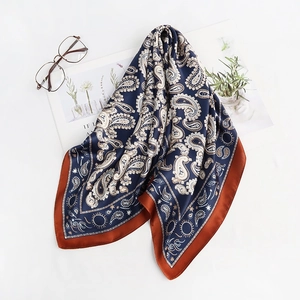 Detail of navy paisley silk scarf with red borders, shown with aesthetic props