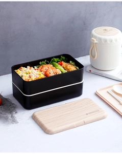 Japanese double-layer black bento box with wooden style lid and fresh meal setup