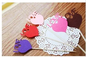 Macro detail of multicolored heart-shaped LOVE cake toppers for anniversary party decor