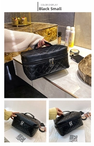 Detail of small black quilted PU leather cosmetic bag with double zippers and handle